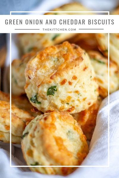 green onion and cheddar biscuits in a basket with text overlay that reads, green onion and cheddar biscuits