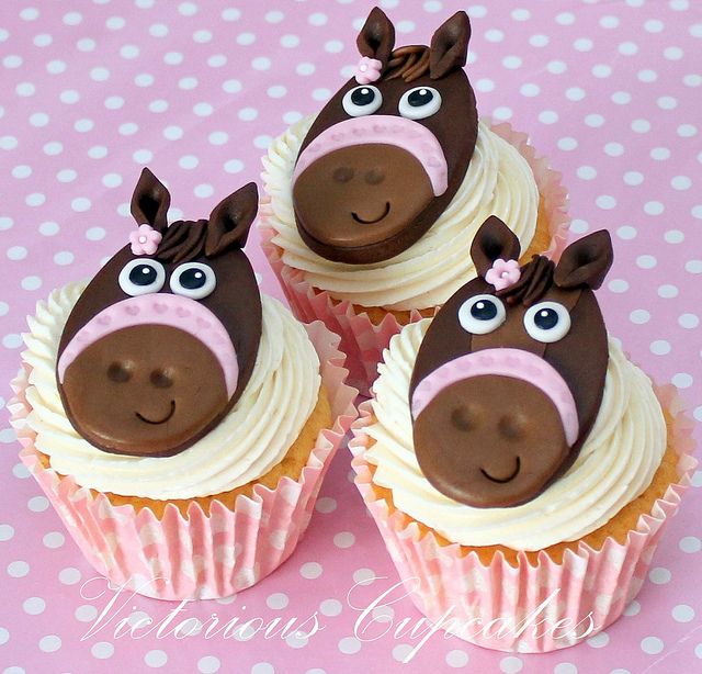 three cupcakes decorated with chocolate and white frosting have faces of horses on them