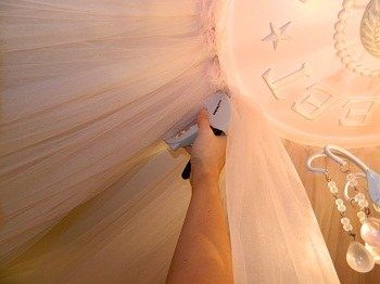 a person is painting the ceiling with white paint and some beads on it's side