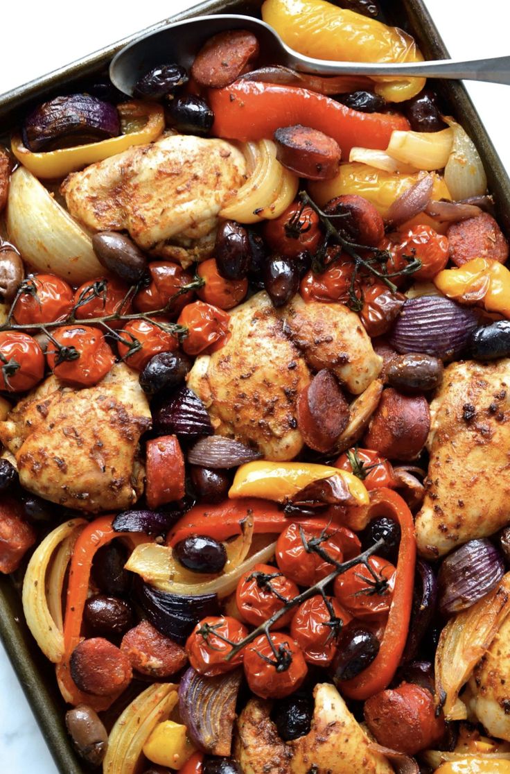 a pan filled with chicken and vegetables on top of a table