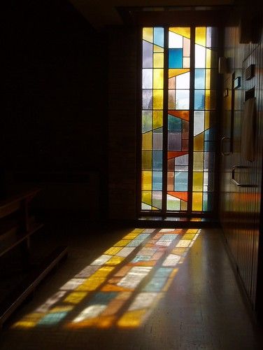 a stained glass window in a church with the sunlight coming through it's windows