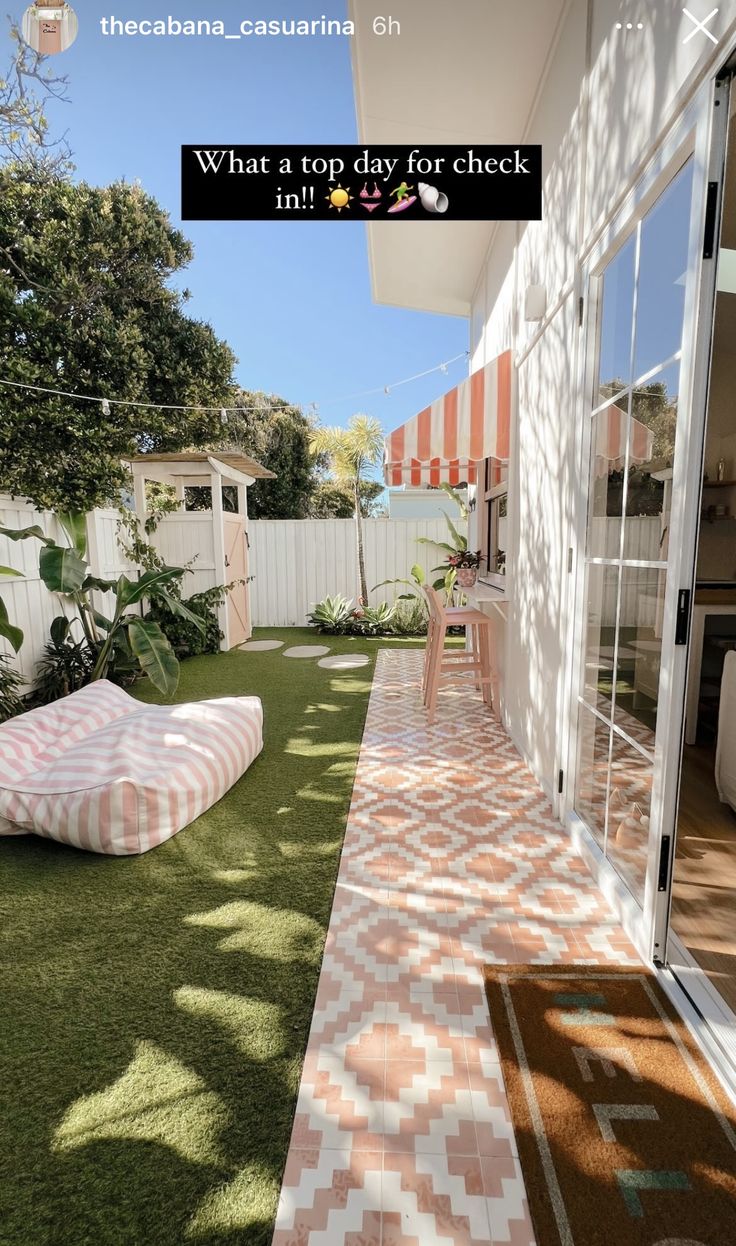 an outdoor area with grass and pink checkered rugs