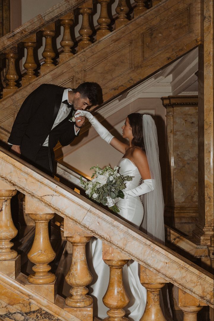 a bride and groom are standing on the stairs