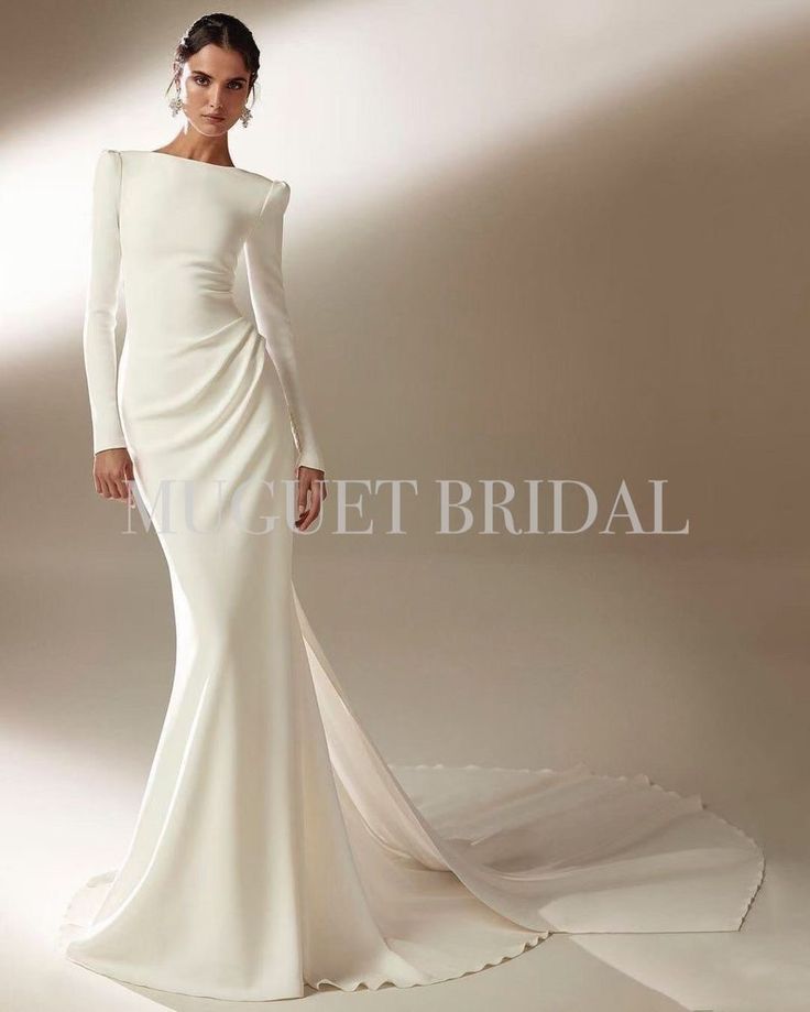 a woman in a white wedding dress with long sleeves and an open back is posing for the camera