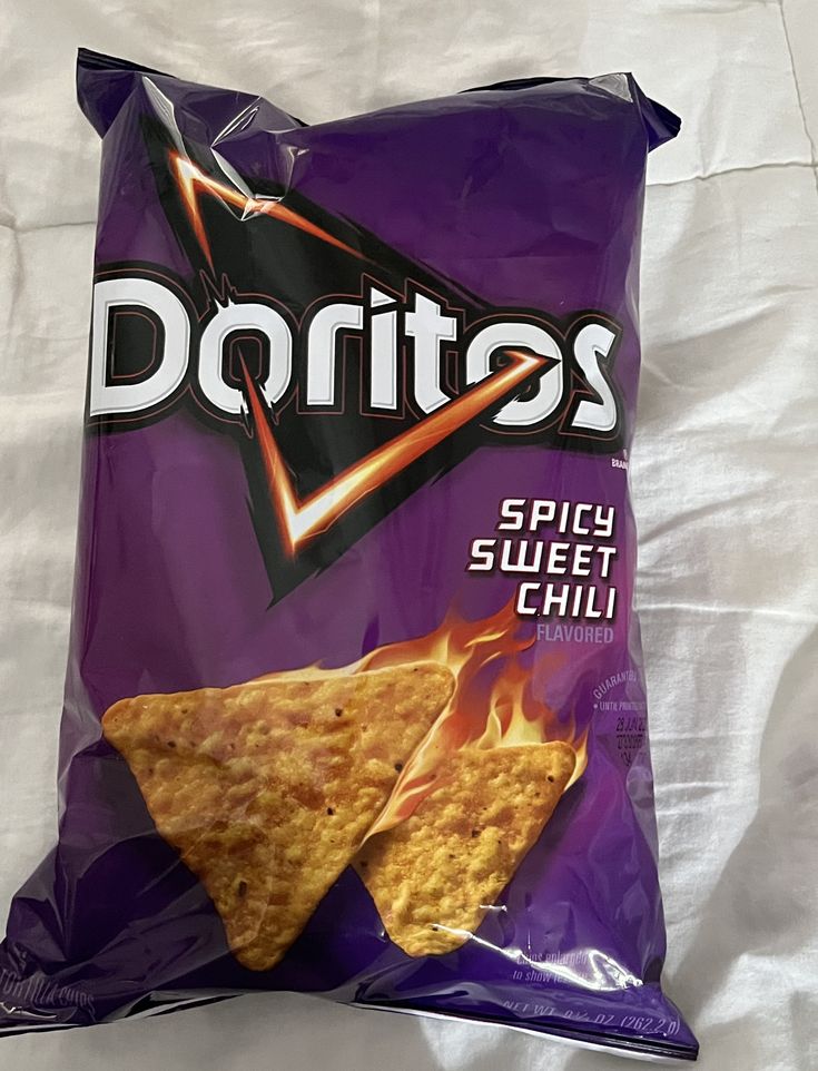 a bag of doritos sitting on top of a bed