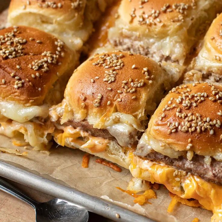 several cheeseburger sliders on a baking sheet