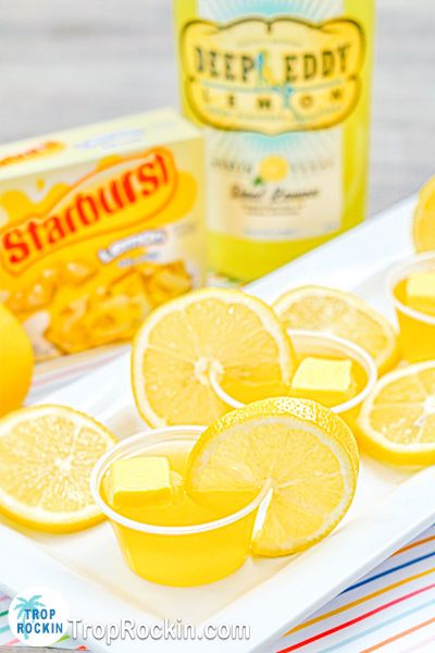 some lemons are sitting on a white plate next to a can of starburst