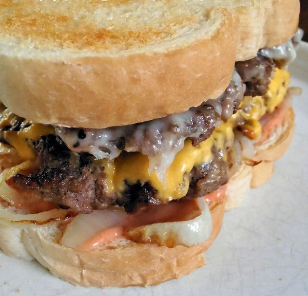 a cheeseburger with meat, onions and melted cheese