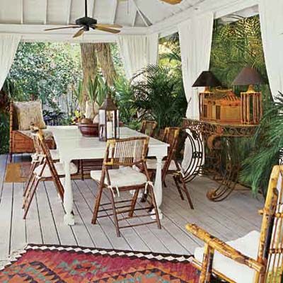 an outdoor dining area with white table and chairs