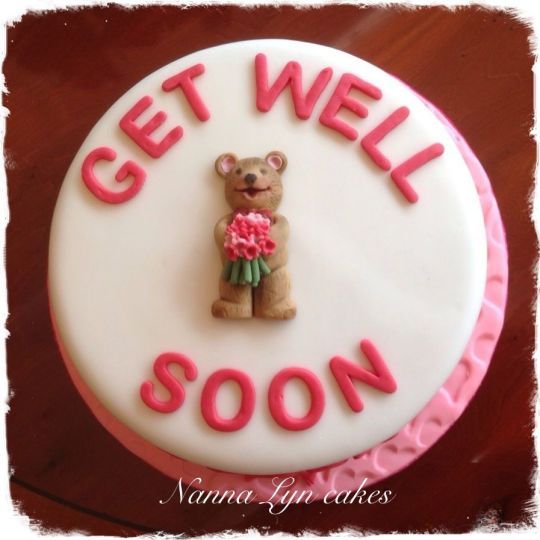 a birthday cake with a teddy bear and flowers on the top that says get well soon