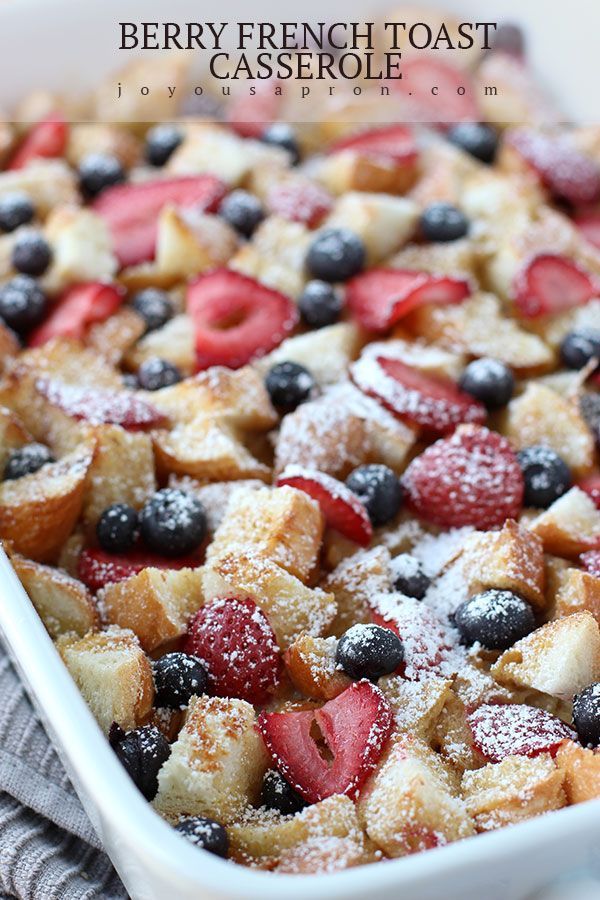 berry french toast casserole with powdered sugar and fresh berries in the baking dish