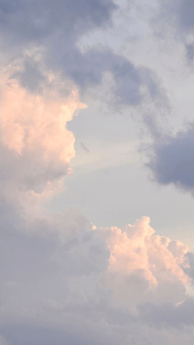 an airplane is flying high in the sky with clouds behind it and another plane on the ground