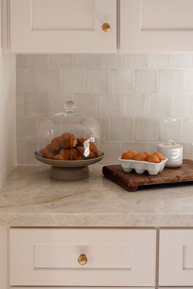 some food is sitting on a counter top in a kitchen with white cabinets and drawers