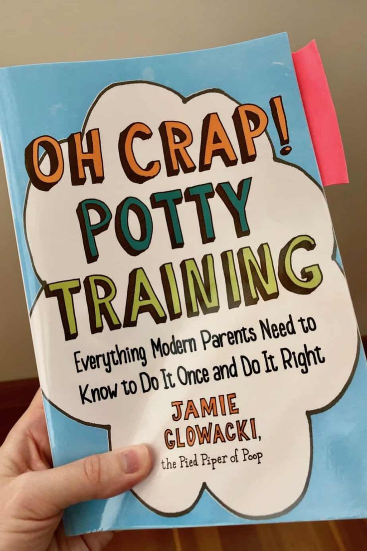 a person holding up a book that says oh crap potty training