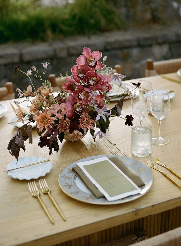 the table is set with flowers and silverware