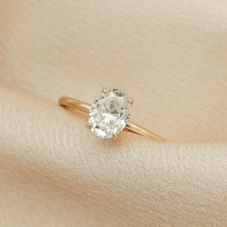 a diamond ring sitting on top of a white cloth