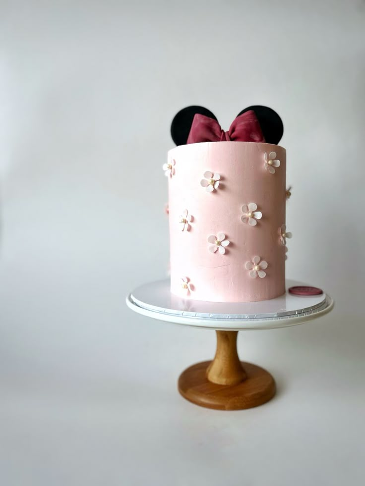 a pink cake with minnie mouse ears on top