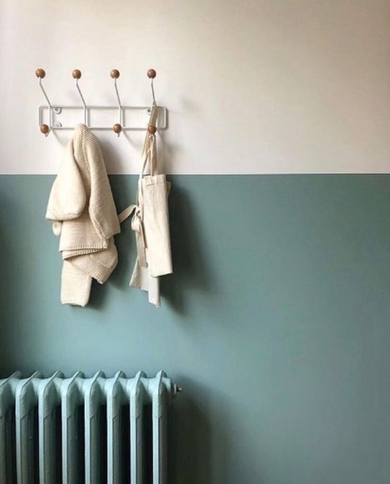 two towels are hanging on a rack next to a radiator