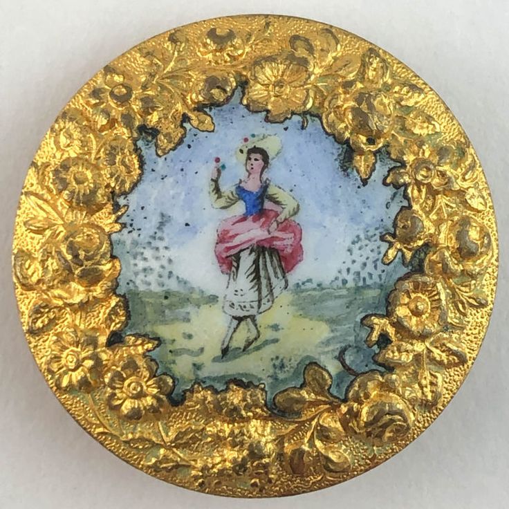 an ornately decorated gold plate with a woman holding a flower in her hand, on a white background