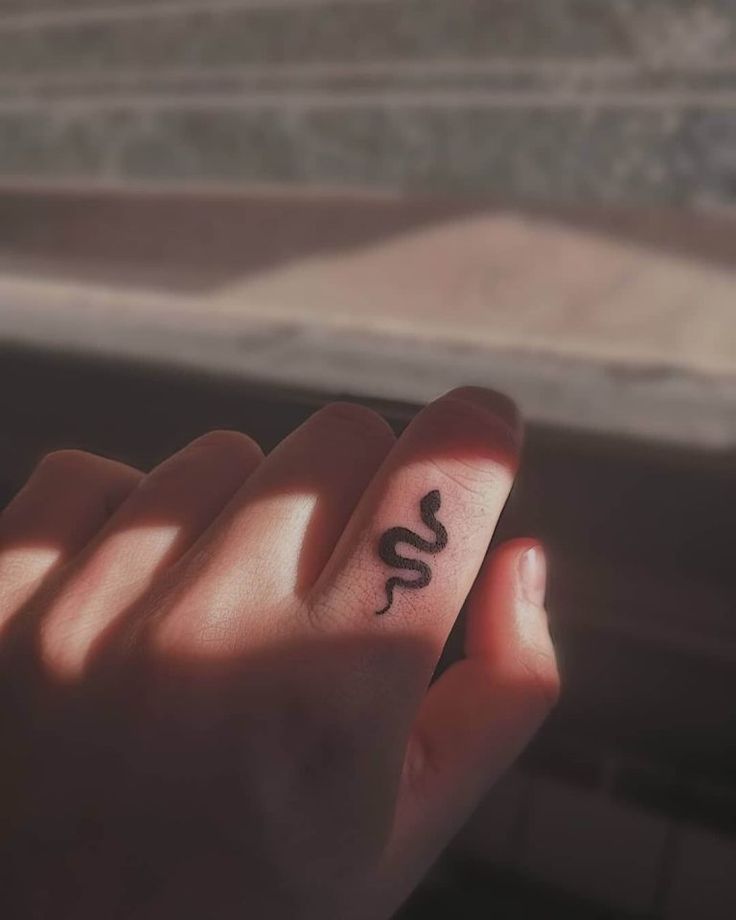 a person's hand with a small tattoo on it