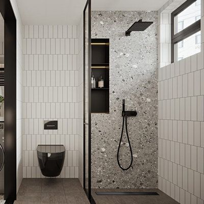 a modern bathroom with black and white tiles on the walls, flooring and shower