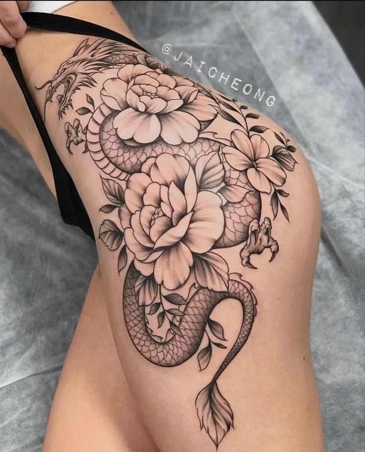 a woman's thigh with flowers and a snake on it