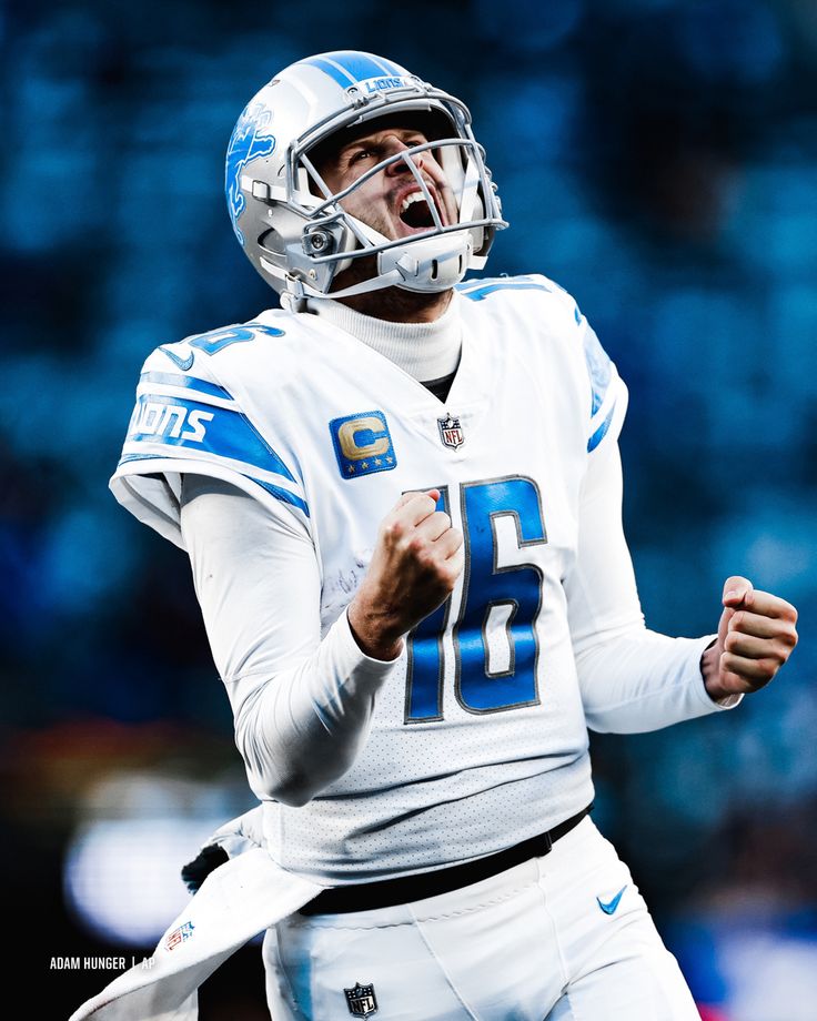 a football player wearing a helmet and holding his fist up