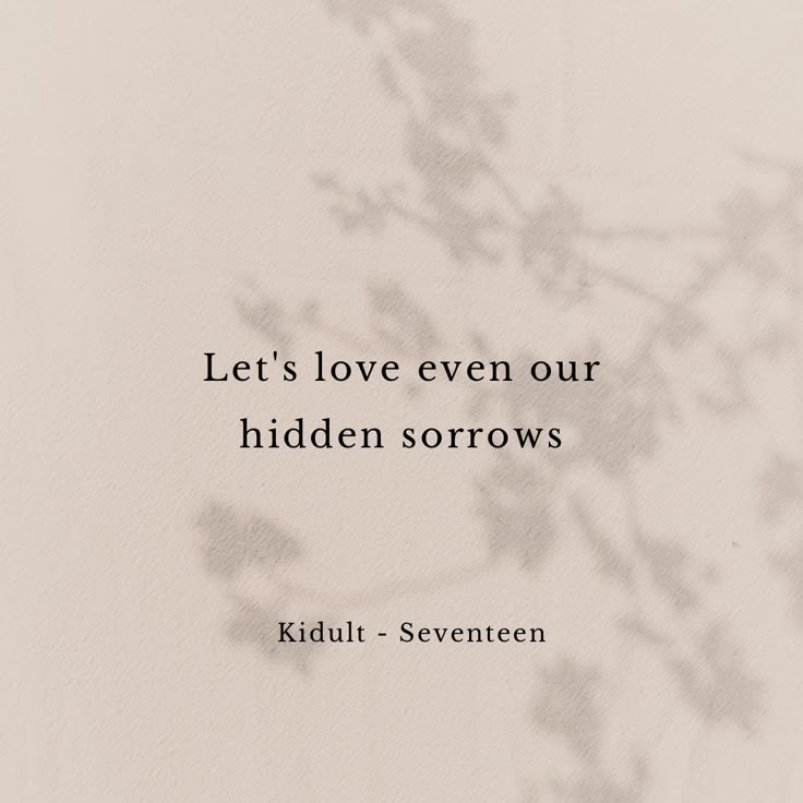 a quote written on the side of a white wall with flowers in front of it that says, let's love even our hidden sororrows