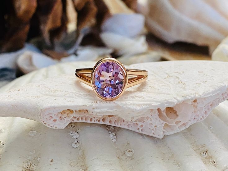 This split shank bezel setting contains a beautiful 2.5 carat natural Rose De France amethyst. The oval cut stone measures approximately 9x7mm and the band is 4.5mm at its widest point. The ring is available in sterling silver, and 14k white, yellow, or rose gold. This ring makes a unique promise or engagement ring. Please send me a message if you need a size not listed. * This ring can be customized with any color center stone. All items are handmade by me in my shop in Manalapan, NJ. Please me Oval Rose Gold Birthstone Ring With Bezel Setting, Oval Solitaire Amethyst Ring Gift, Oval Solitaire Amethyst Ring For Anniversary, Oval Amethyst Birthstone Ring With Bezel Setting, Oval Purple Birthstone Ring With Bezel Setting, Oval Kunzite Ring For Anniversary, Purple Oval Birthstone Ring With Bezel Setting, Lavender Amethyst Ring With Oval Shape, Oval Amethyst Ring With Bezel Setting