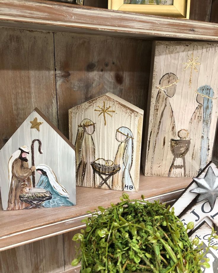 three wooden nativity figurines sitting on top of a shelf