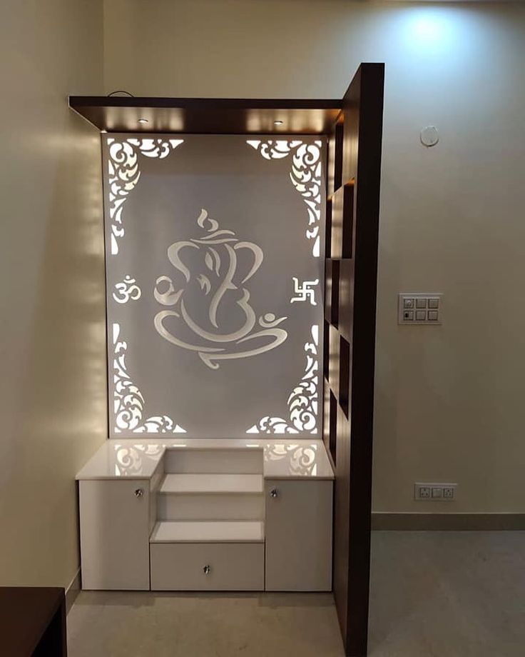 a white and brown display case with an intricate design on the wall behind it in a room