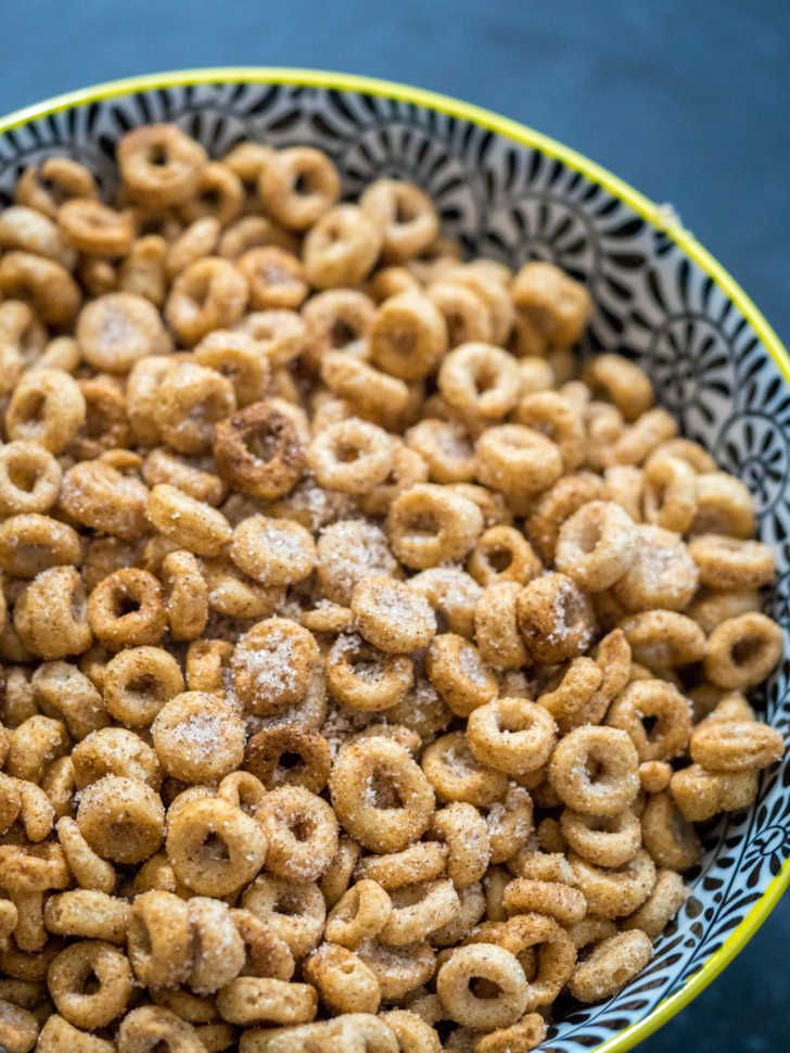 a bowl filled with cereal and powdered sugar on top of a blue tablecloth