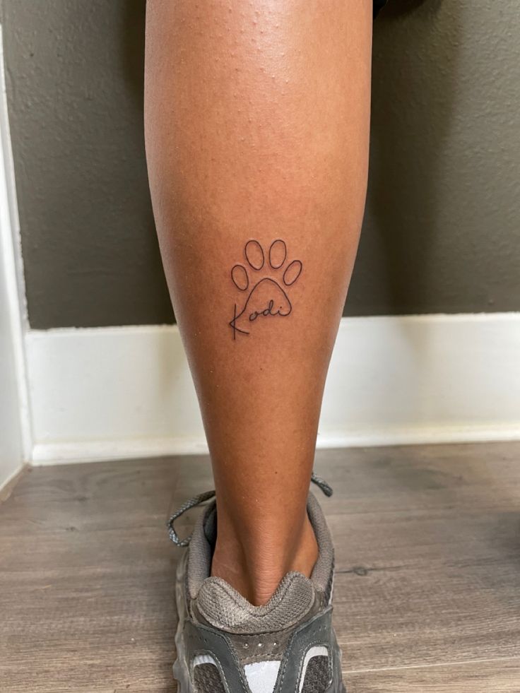 a person with a dog paw tattoo on their leg