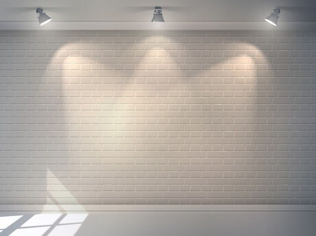 an empty room with three spotlights on the brick wall and two lamps above it