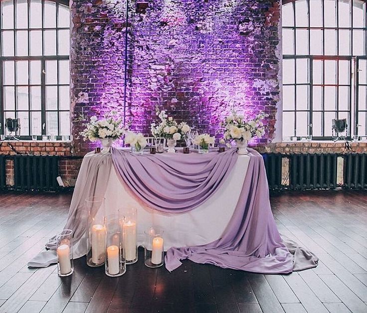 the table is set up with candles and flowers on it for an elegant wedding reception