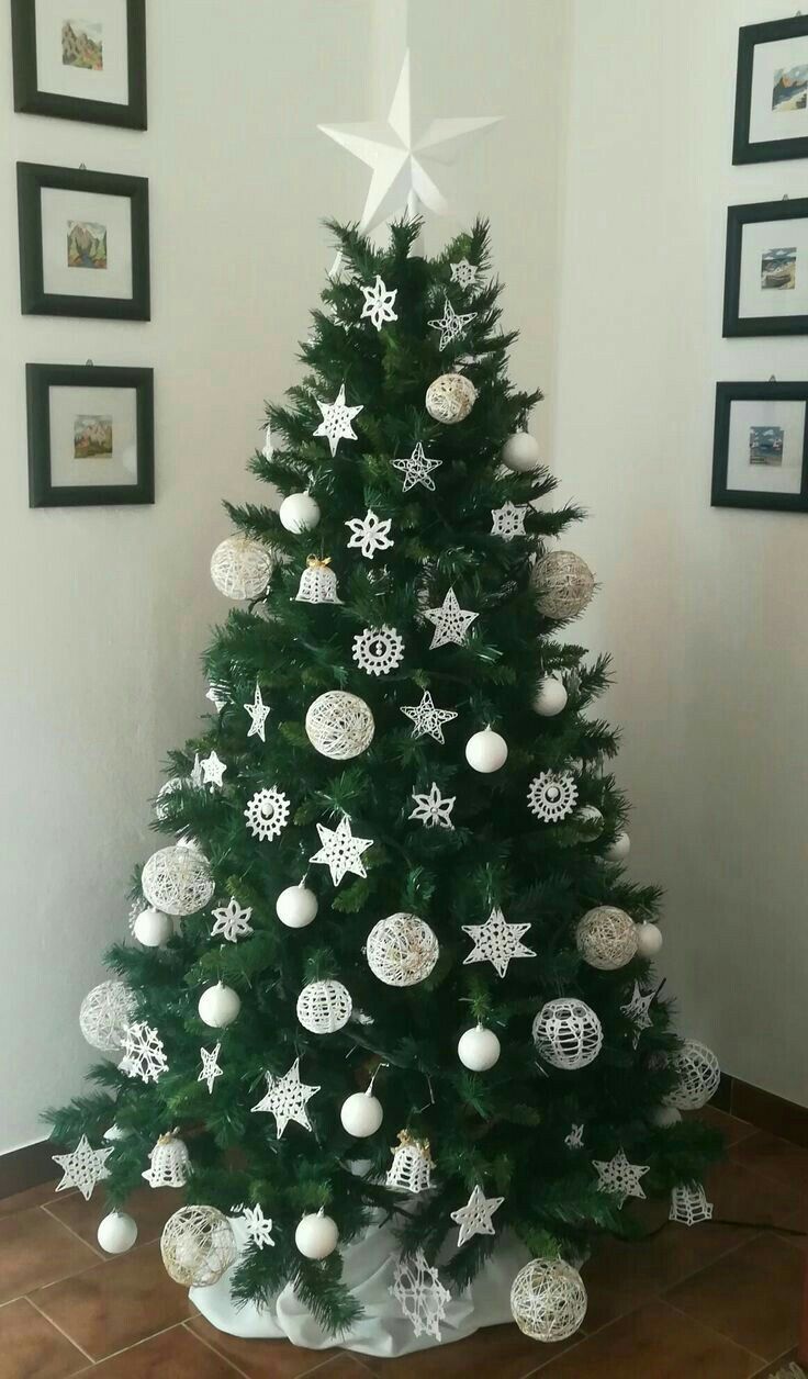 a decorated christmas tree with white and silver ornaments