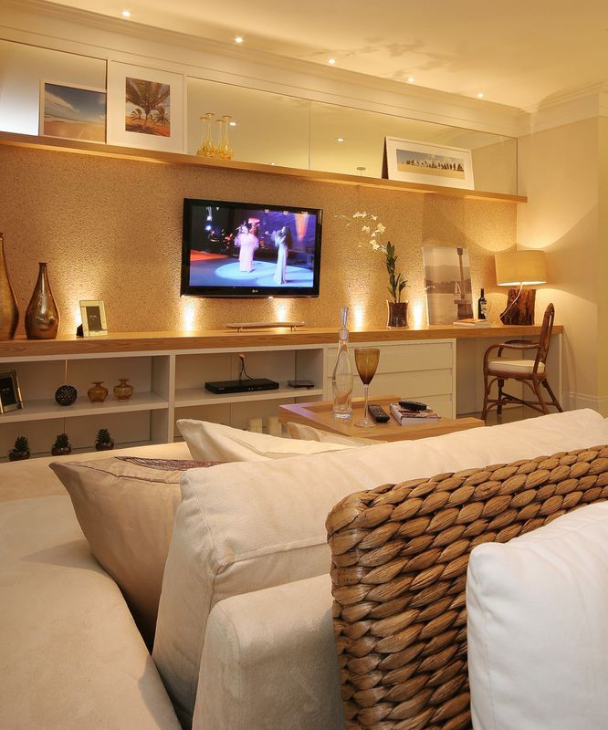 a living room filled with lots of furniture and a flat screen tv mounted on the wall