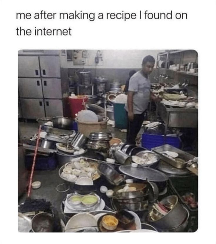 a man standing in a kitchen surrounded by pots and pans