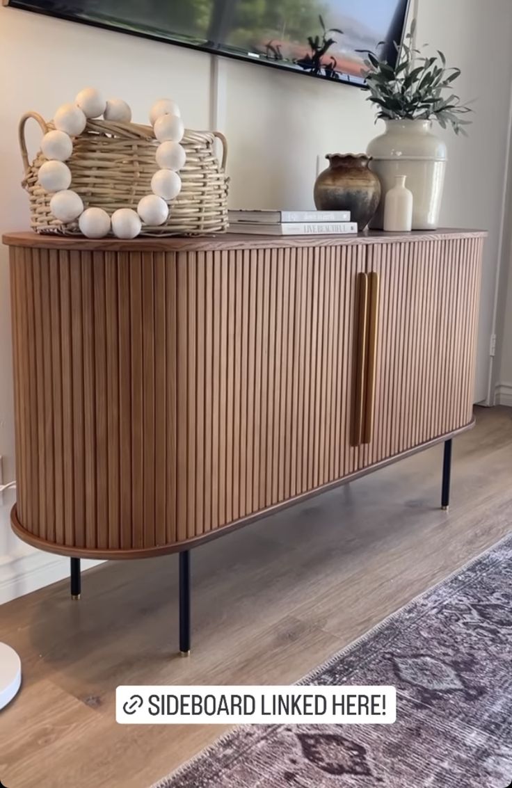 a large wooden cabinet sitting on top of a hard wood floor next to a rug