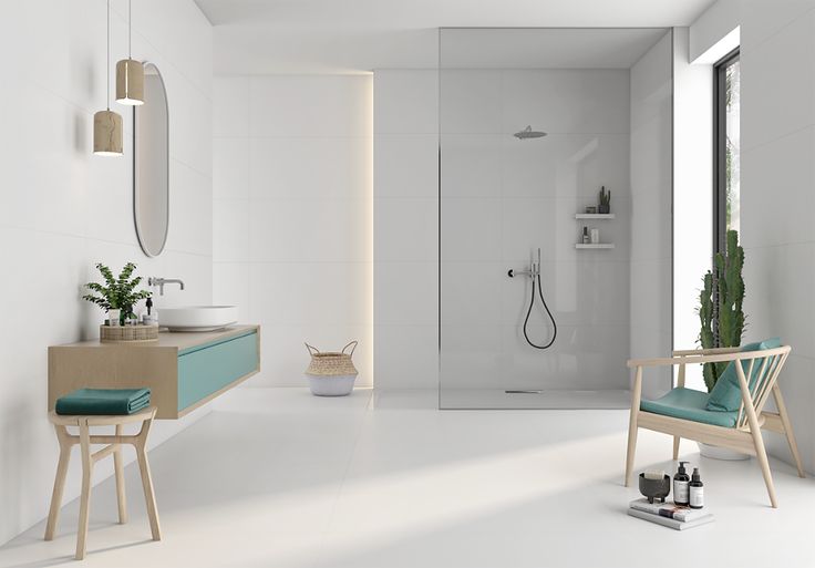 a bathroom with white walls and flooring has a blue chair in front of the shower