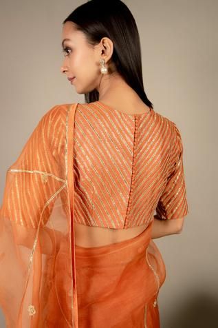 Orange saree in organza base with embroidered floral buttis. Paired with chanderi blouse. Comes with satin petticoat.
Component: 3
Pattern: Embroidered
Type Of Work: Floral Motifs
Neckline: Crew
Sleeve Type: Half Sleeves
Fabric: Saree: Organza; Blouse; Chanderi; Petticoat: Satin
Color: Orange
Other Details: 
Striped work on blouse
Back potli buttons on blouse
Occasion: Wedding - Aza Fashions Ikshita Choudhary, Saree Organza, Orange Saree, Organza Blouse, Hand Work Blouse, Embroidered Saree, Hand Work Blouse Design, Satin Color, Blouse Work Designs