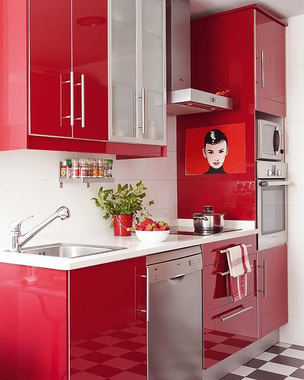 a red and white kitchen with checkered flooring on the walls, stainless steel appliances and cabinets