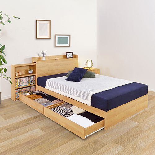 a bed sitting on top of a wooden floor next to a plant