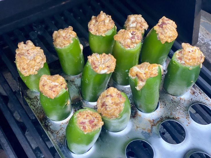 several green peppers are being cooked on the grill