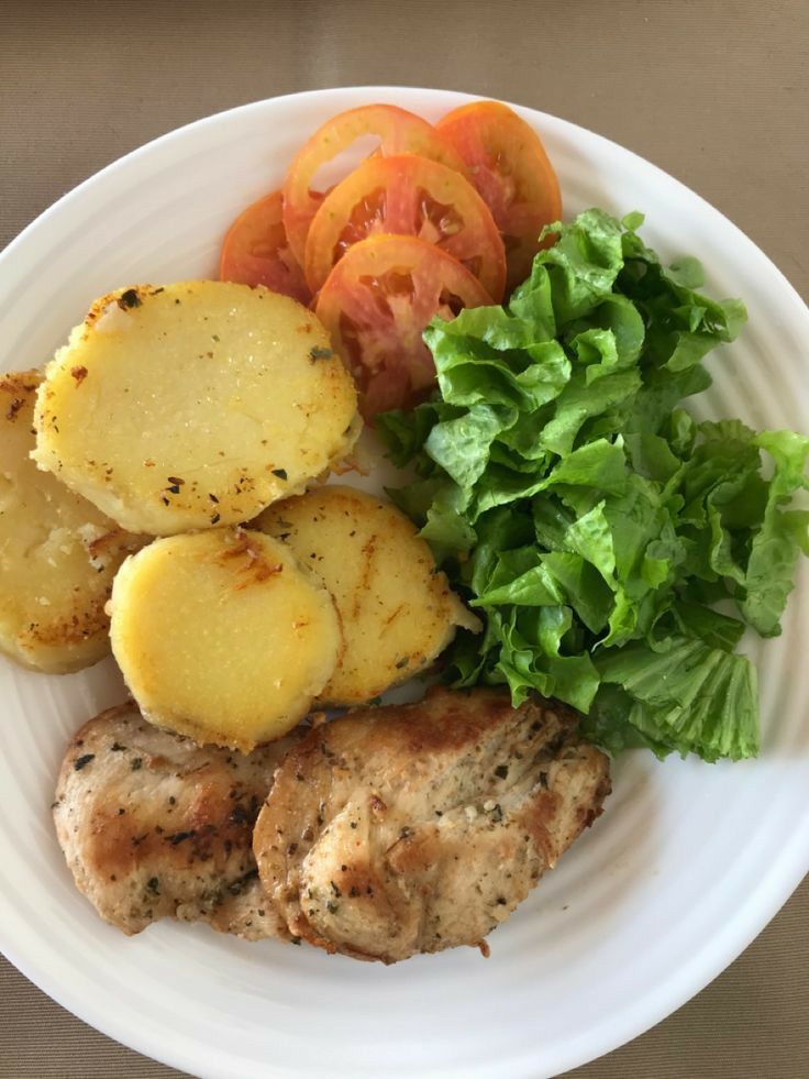 a white plate topped with meat, potatoes and veggies