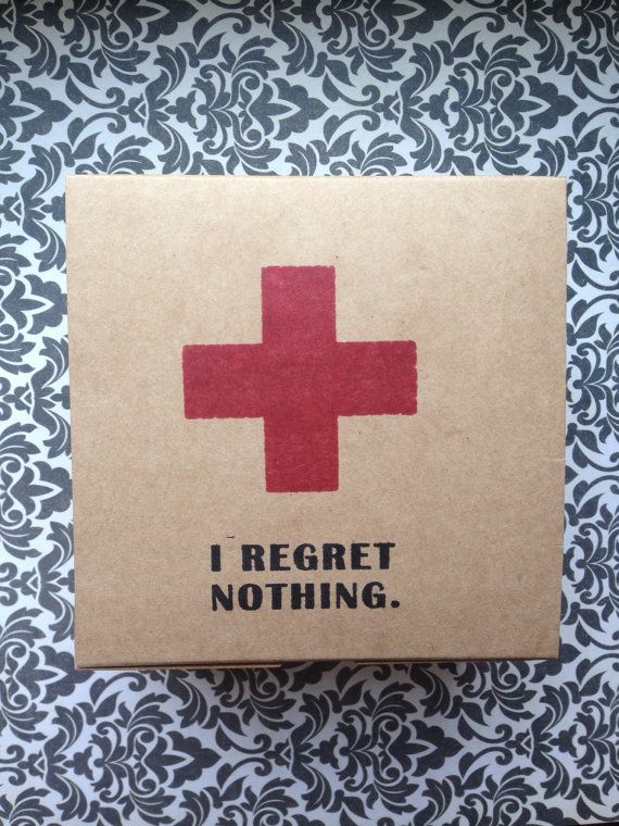 a red cross sticker on top of a brown box with black and white wallpaper