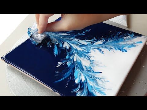 someone is painting something blue and white on a table