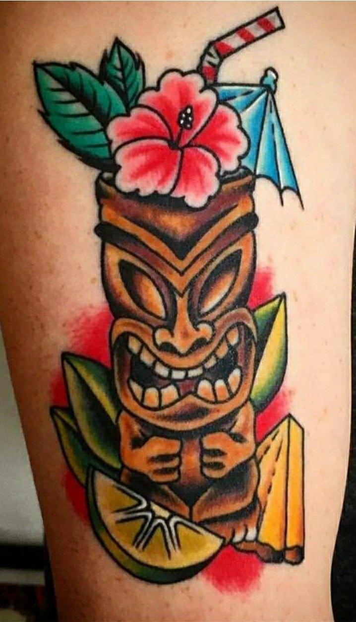 a tiki tattoo on the back of a woman's leg