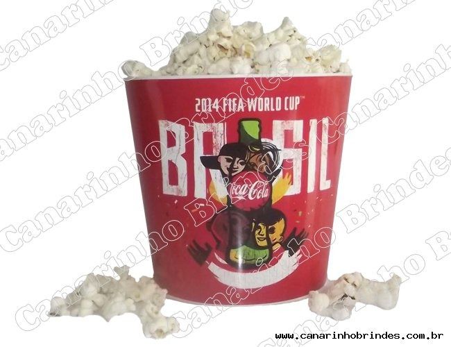 a bucket filled with white popcorn sitting on top of a table