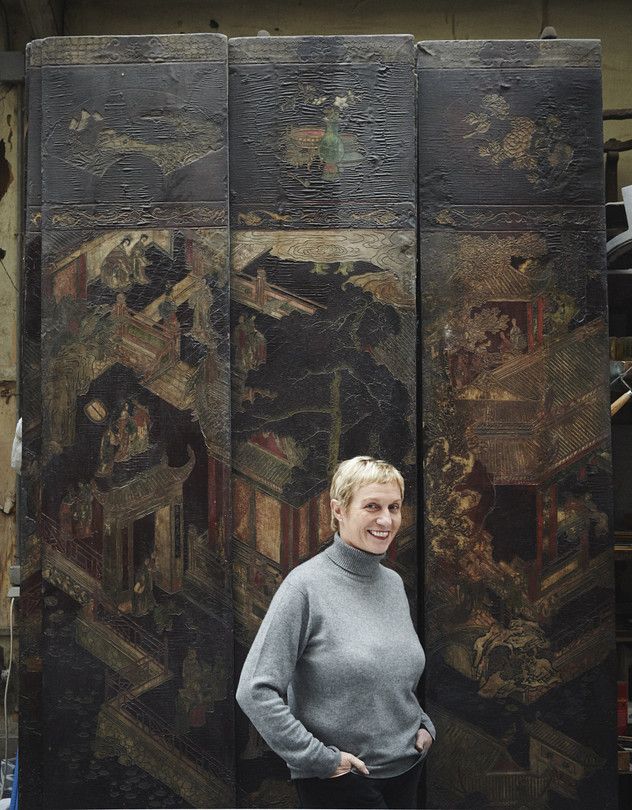 a woman standing in front of some paintings